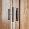 Heavy-duty barn door components including steel track, rollers, and latch for large wooden doors